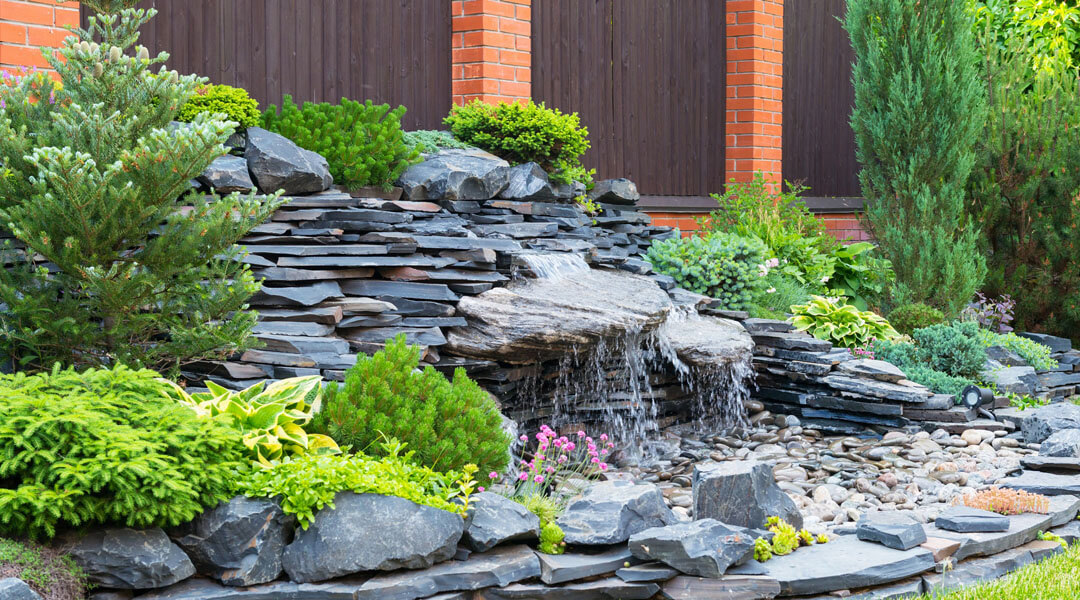 Domestic garden showing rocks, fence and waterfall